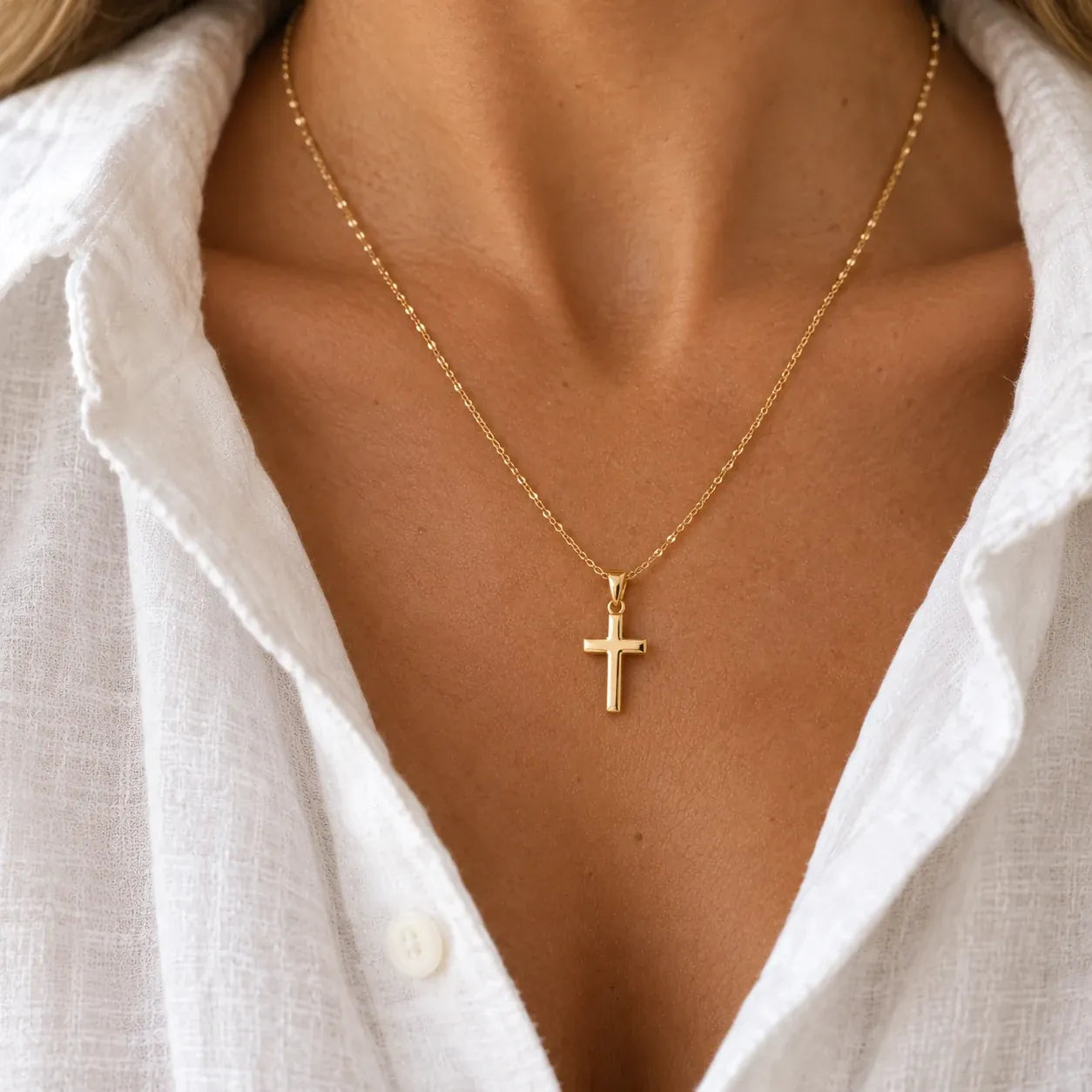Gold cross pendant on chest